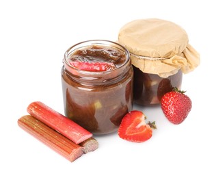 Tasty rhubarb jam in jars, cut stems and strawberries on white background