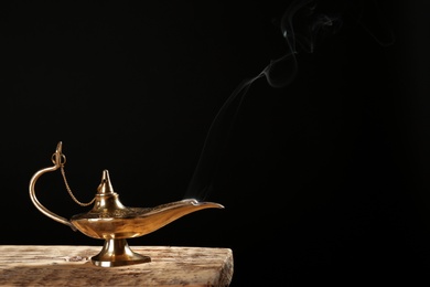 Aladdin magic lamp on table against black background