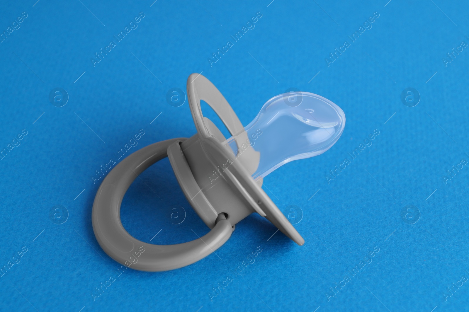 Photo of One new baby pacifier on blue background