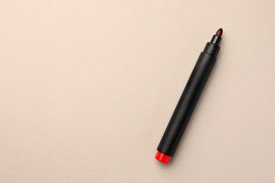 Bright red marker on beige background, top view. Space for text