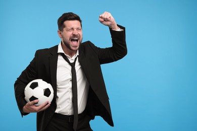 Emotional sports fan with ball celebrating on light blue background. Space for text