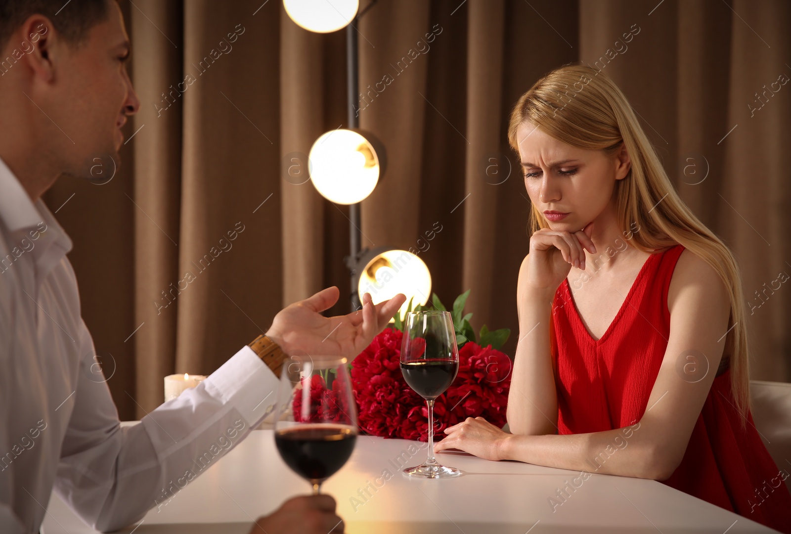 Photo of Displeased young woman and overtalkative man in restaurant. Failed first date