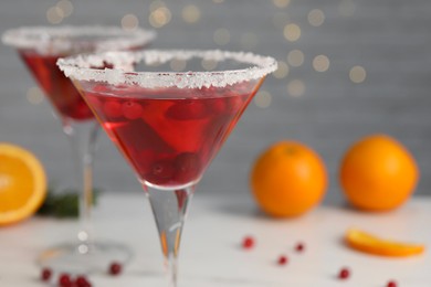 Tasty cranberry cocktail in glasses on light background, closeup