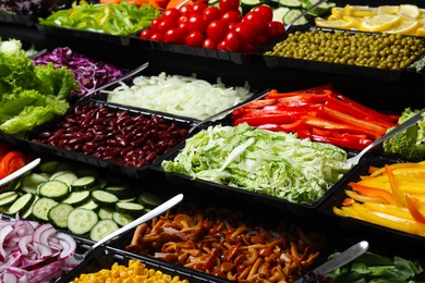 Salad bar with different fresh ingredients as background