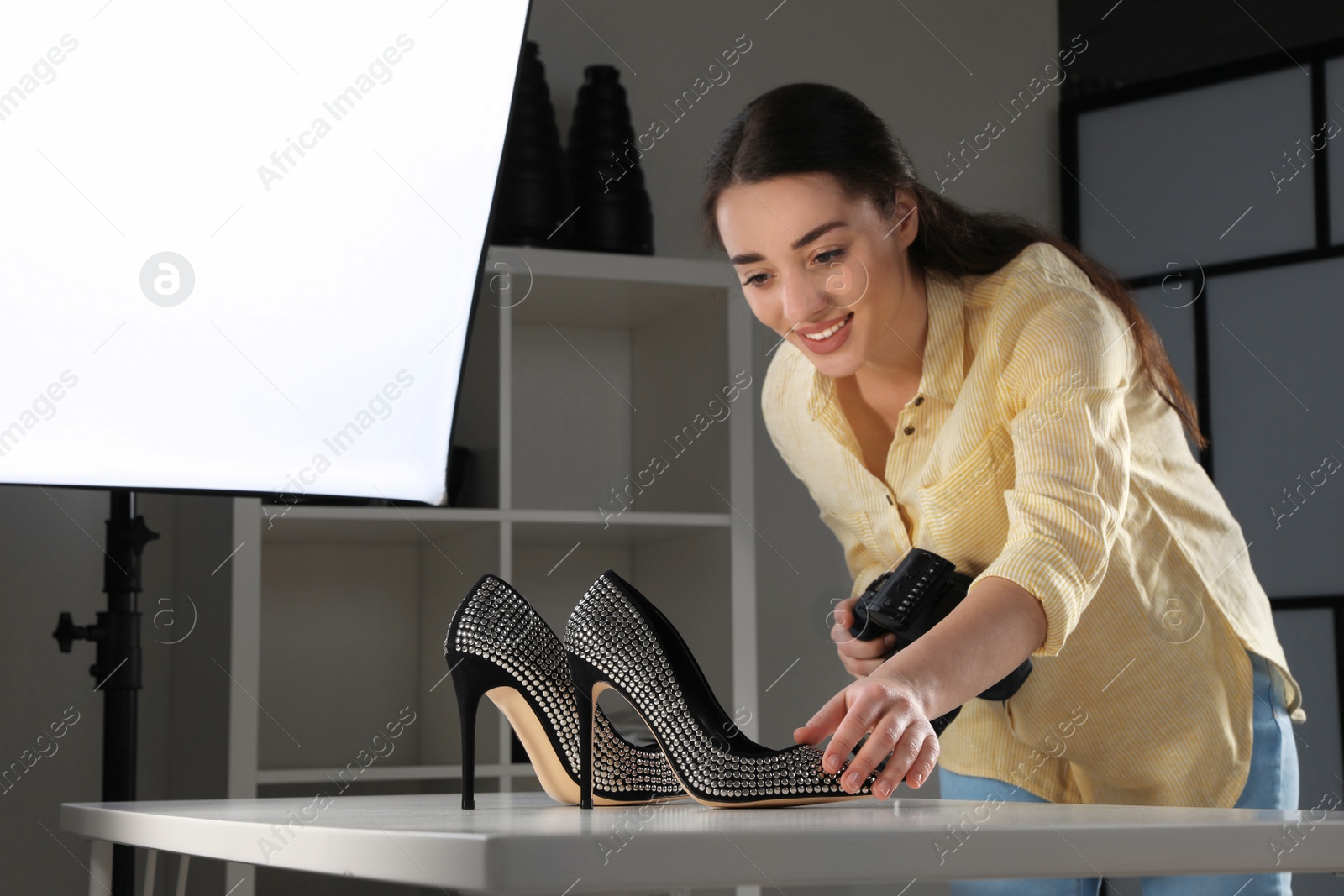 Photo of Professional photographer shooting stylish shoes in studio