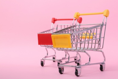 Photo of Empty shopping trolleys on color background. Space for text