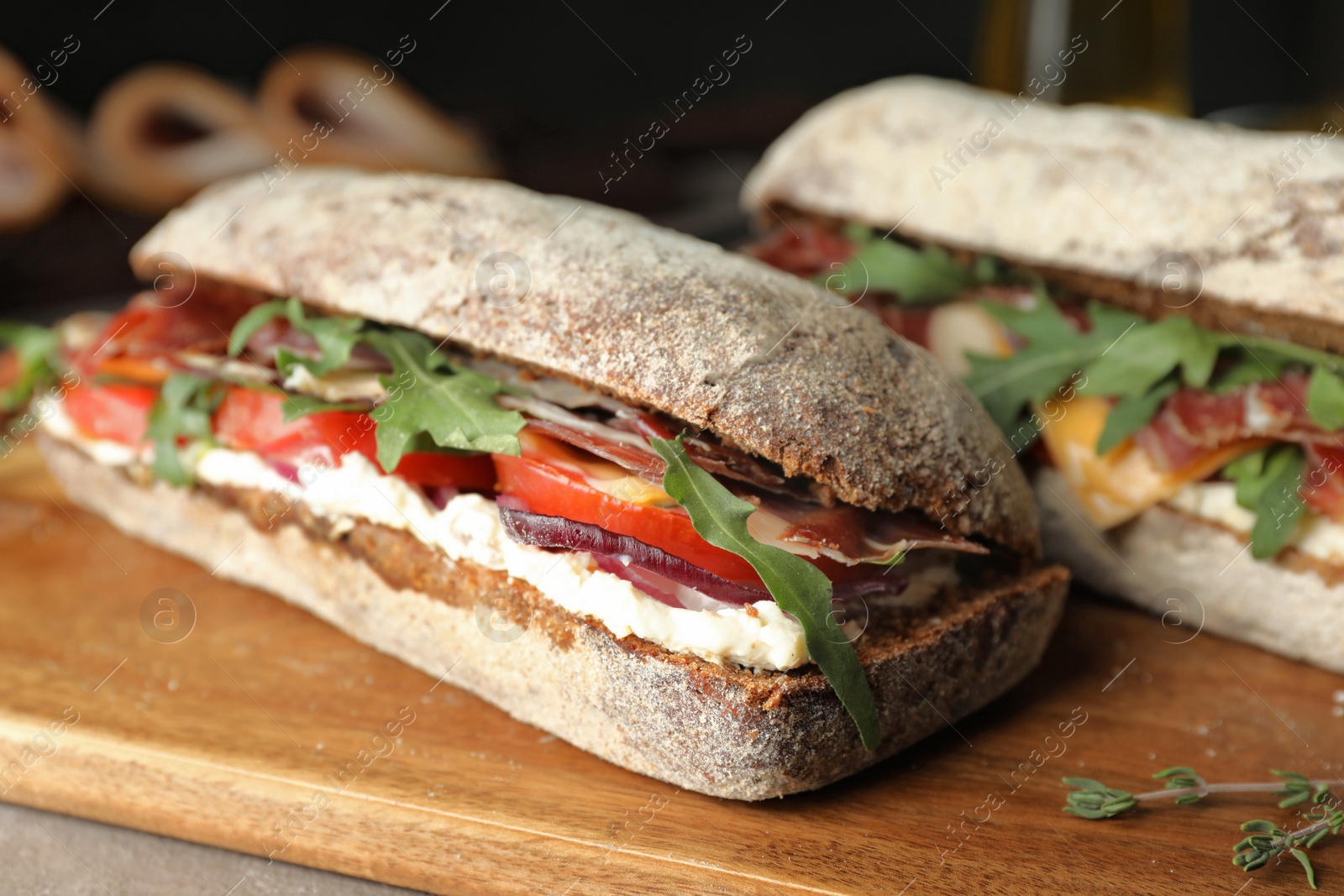 Photo of Delicious sandwiches with fresh vegetables and prosciutto on table, closeup