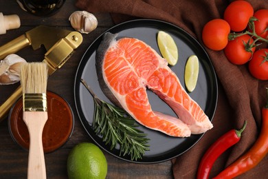 Photo of Fresh fish, products and marinade on wooden table, flat lay