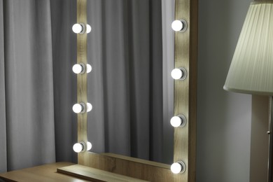 Photo of Beautiful mirror with light bulbs in makeup room