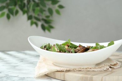 Photo of Delicious salad with beef tongue, arugula and seeds on white marble table. Space for text