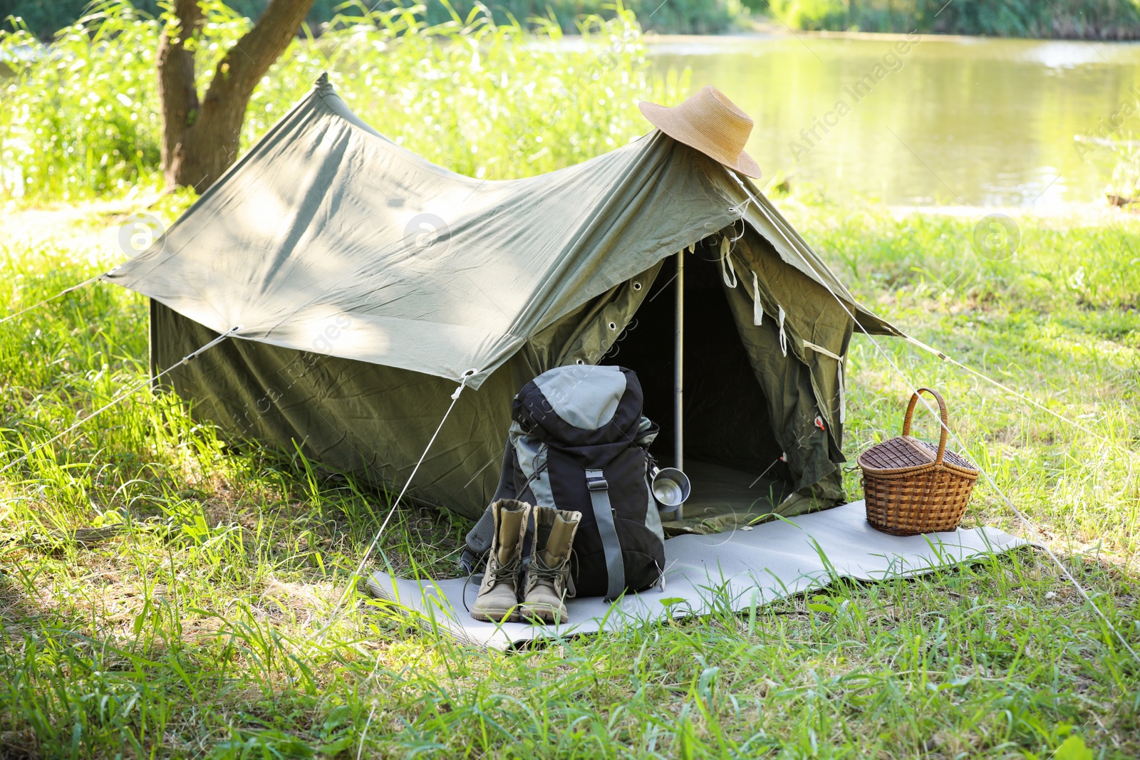 Photo of Traveling gear near tent outdoors. Summer camp