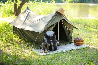 Photo of Traveling gear near tent outdoors. Summer camp