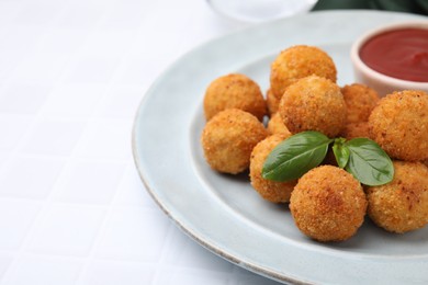 Photo of Delicious fried tofu balls with basil and ketchup on white tiled table, closeup. Space for text