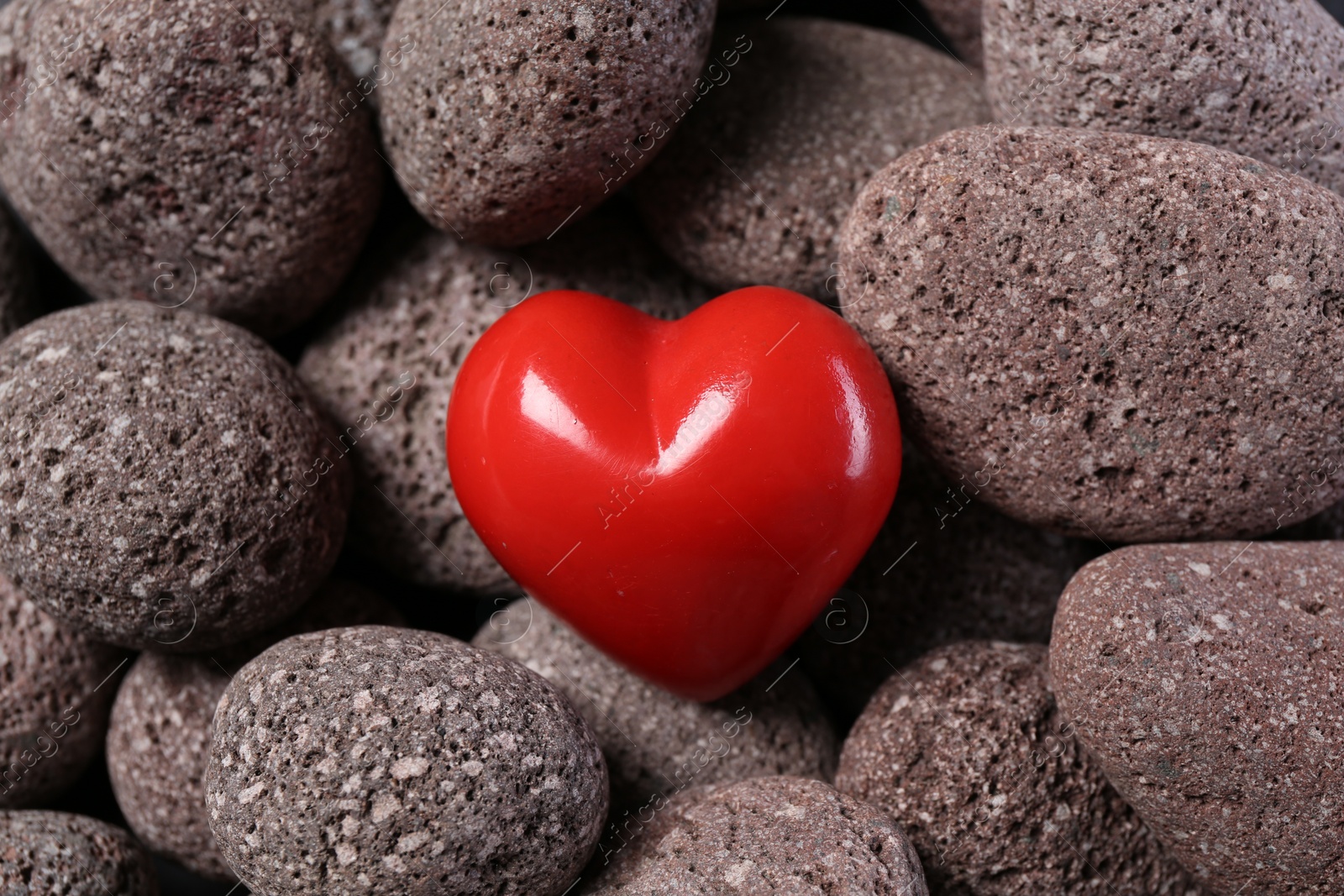 Photo of One red decorative heart on stones, above view