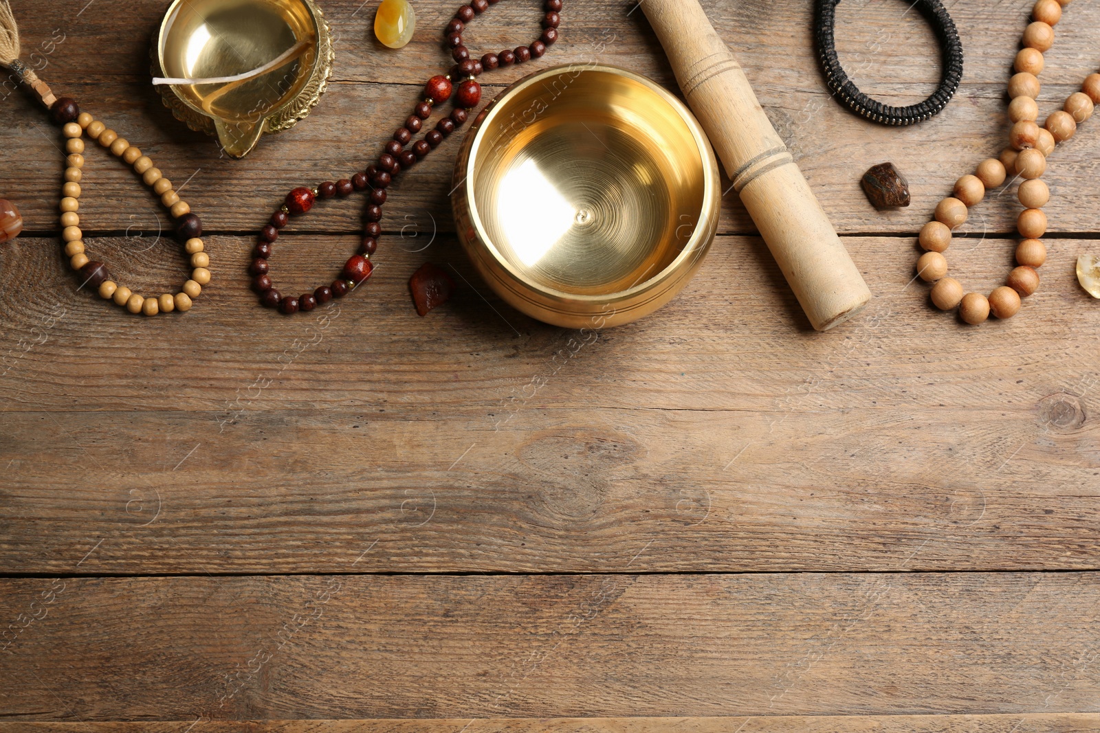 Photo of Flat lay composition with golden singing bowl on wooden table, space for text. Sound healing