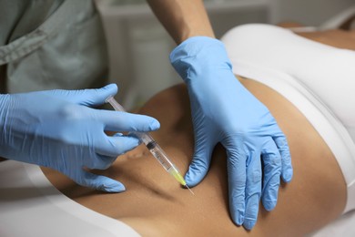 Young woman getting belly injection in salon, closeup