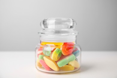 Photo of Tasty jelly candies in jar on white table