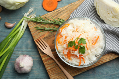 Photo of Flat lay composition with fermented cabbage on blue wooden table