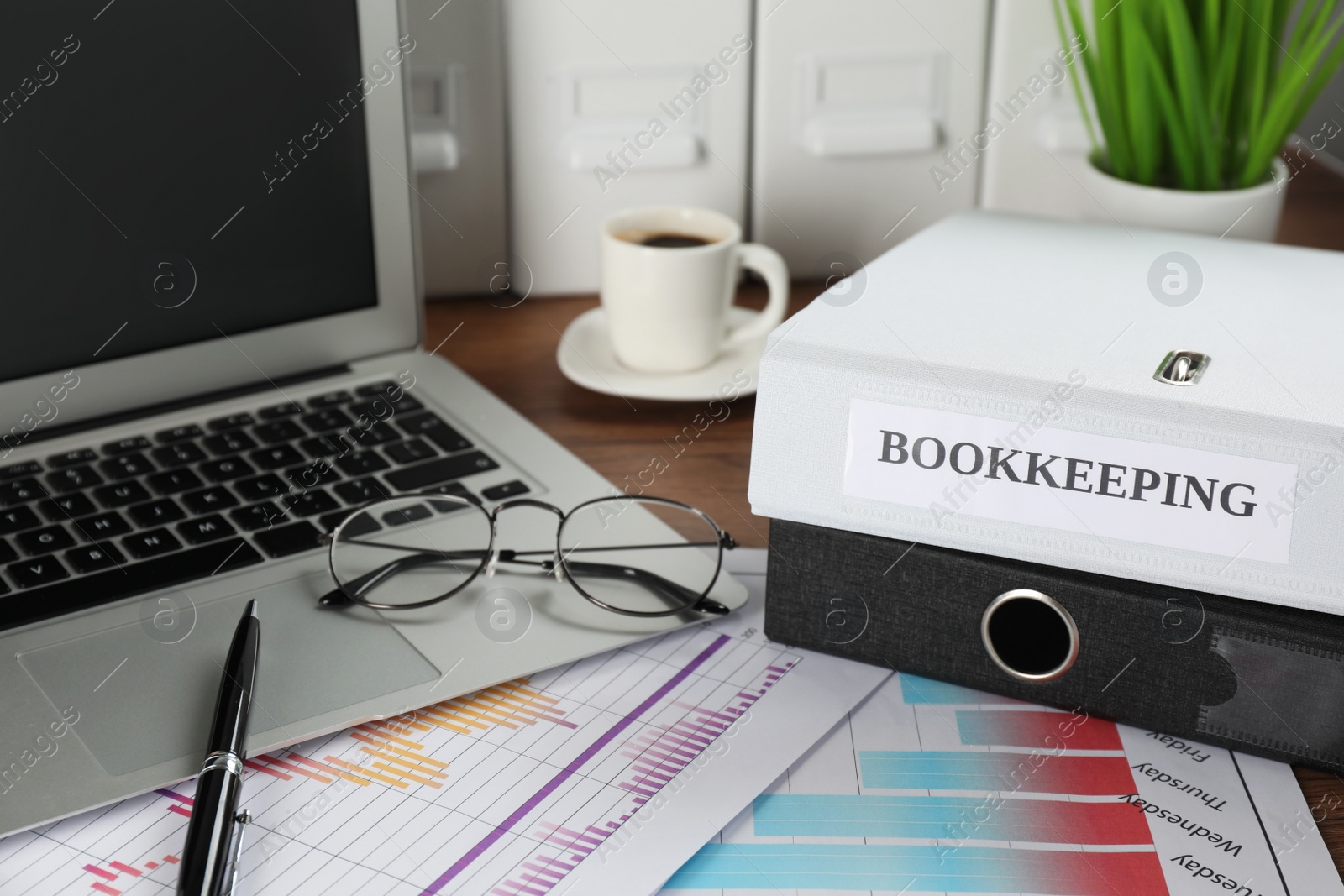 Photo of Folders, laptop and documents on desk in office. Bookkeeper's workplace