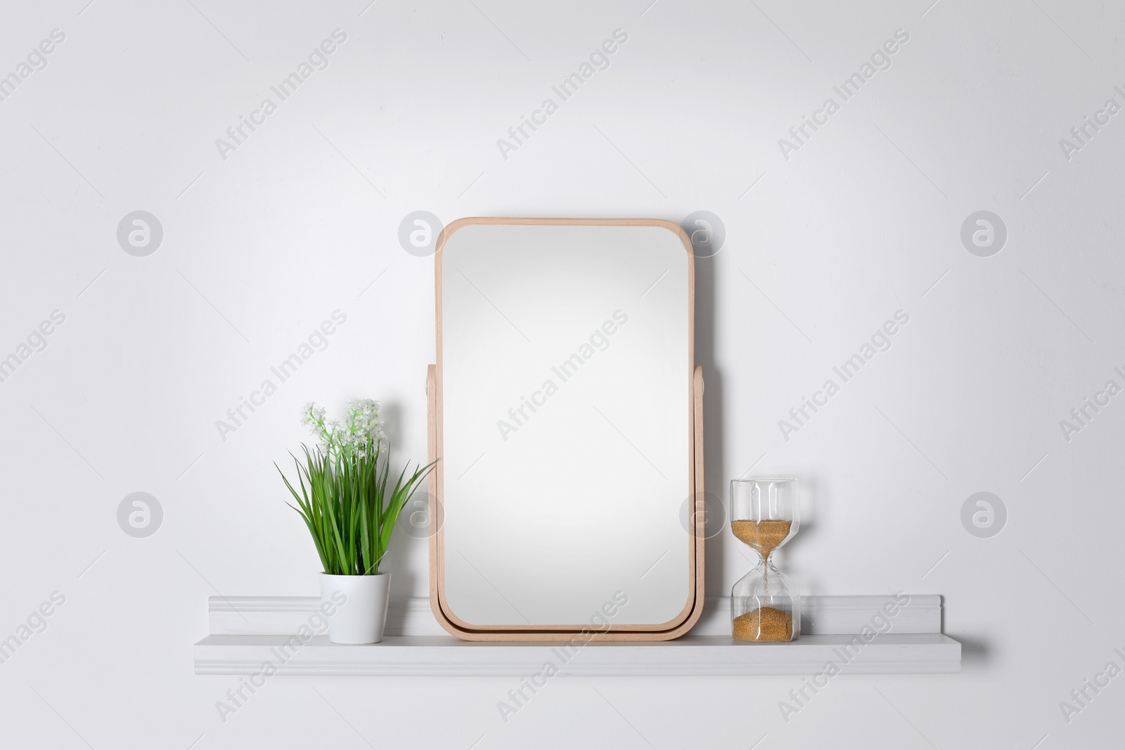 Photo of Shelf with modern mirror on white wall
