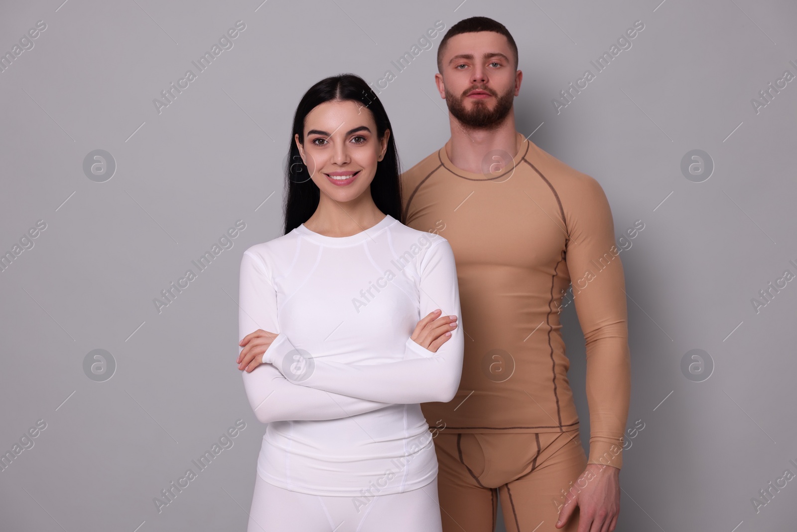 Photo of Man and woman in warm thermal underwear on grey background