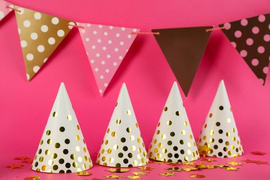 Colorful party hats and other festive items on pink background