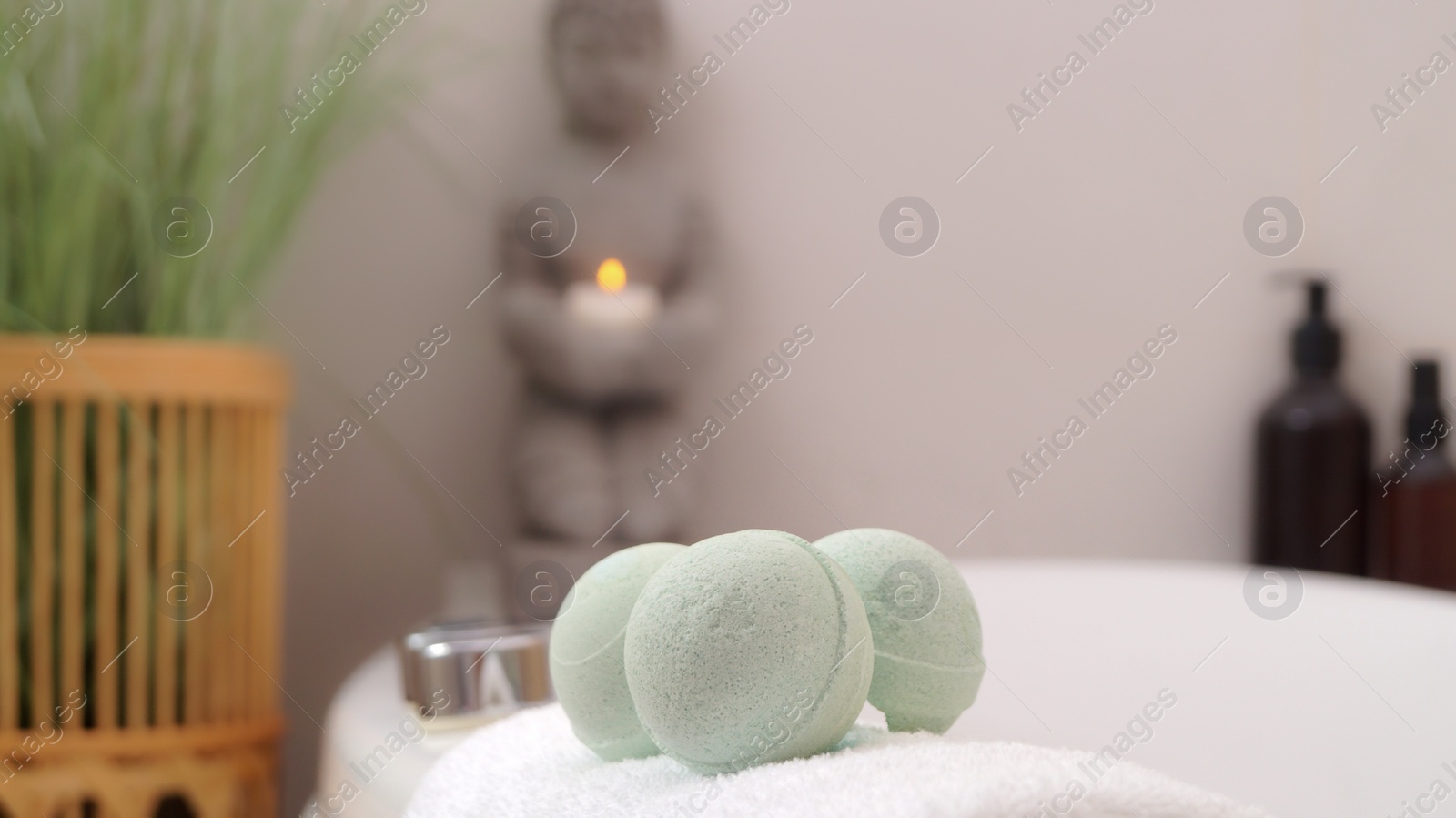 Photo of Towel with bath bombs on tub indoors