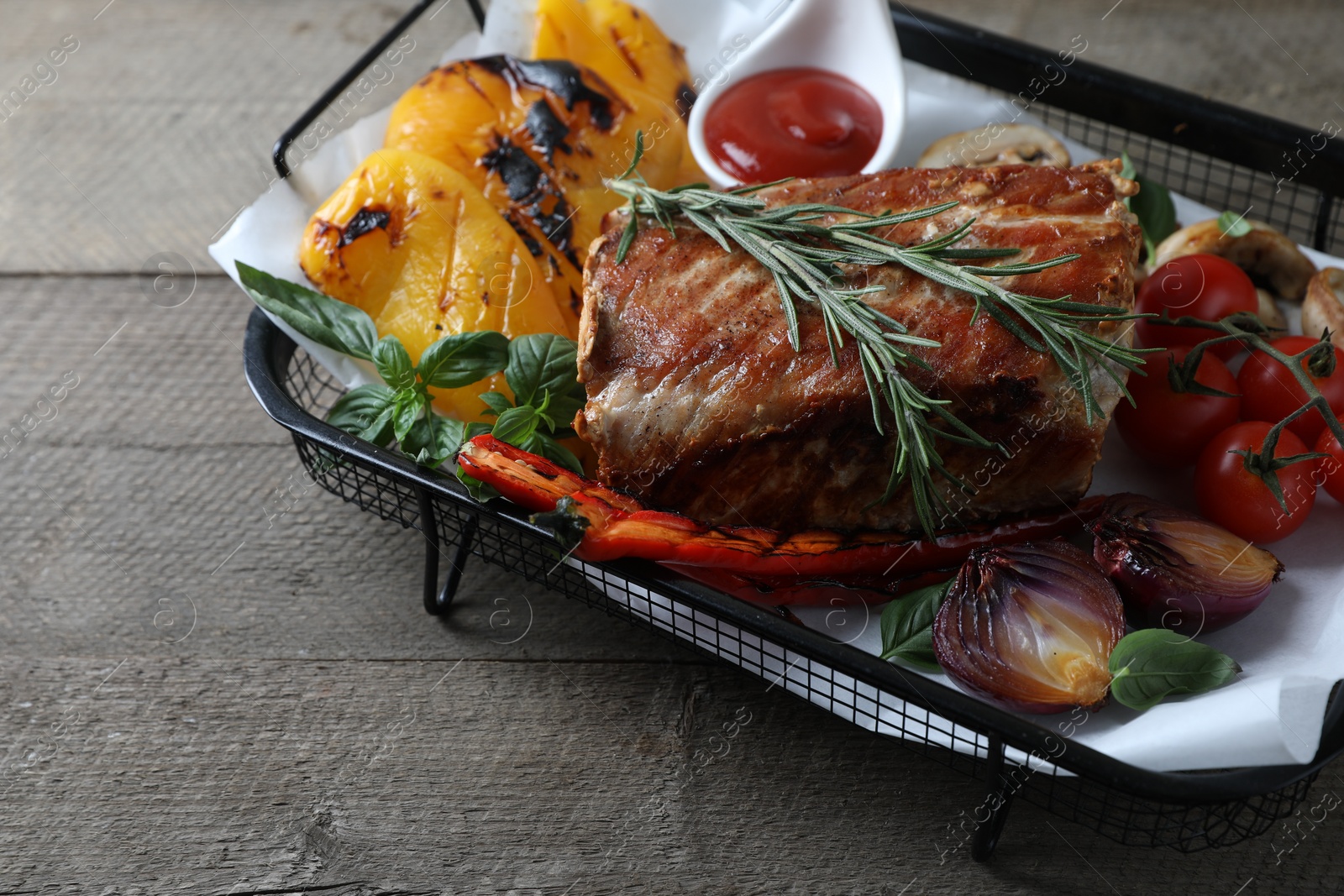 Photo of Delicious grilled meat and vegetables served with sauce on wooden table, closeup