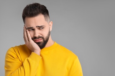 Portrait of sad man on light grey background, space for text