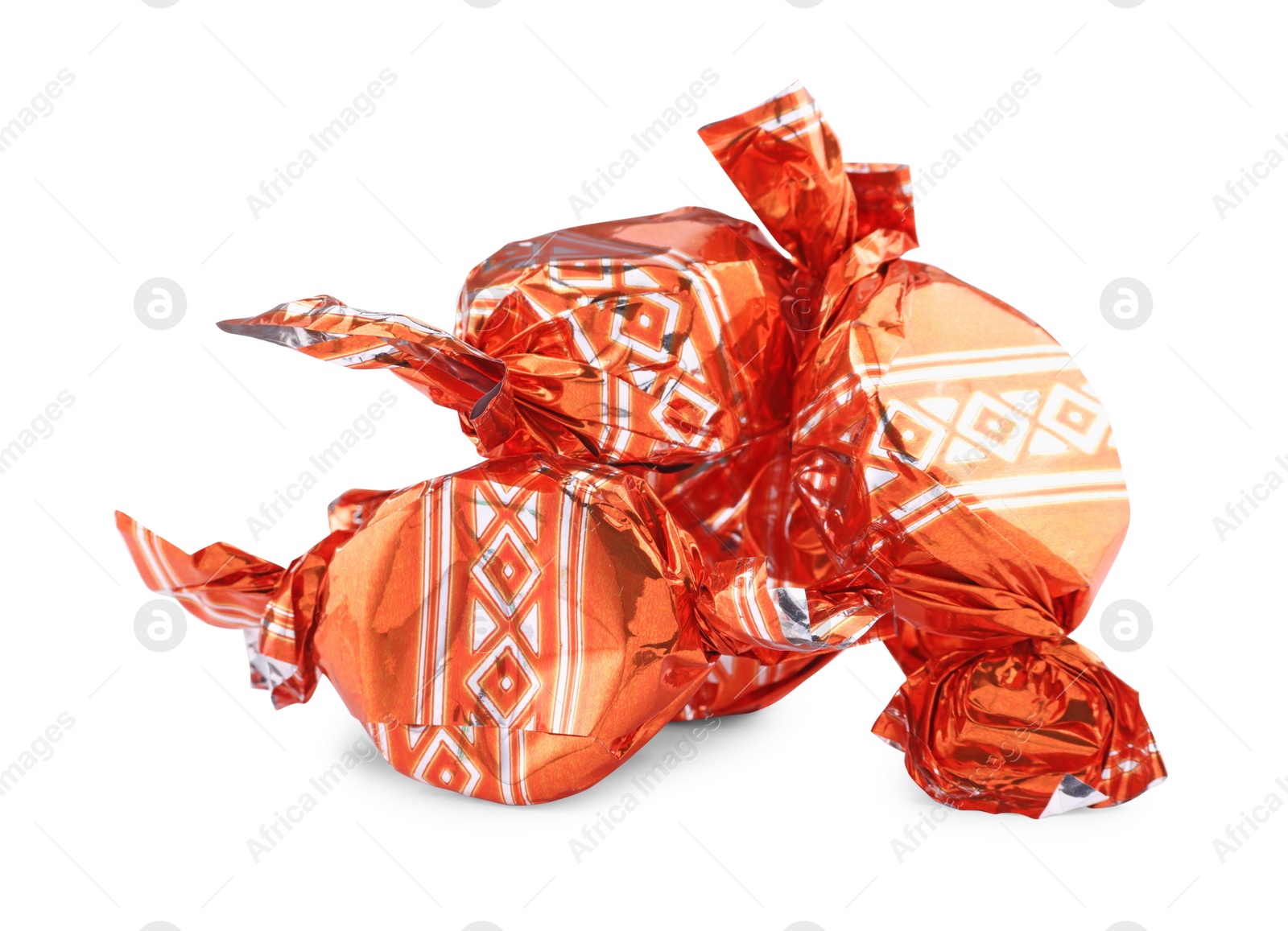 Photo of Candies in orange wrappers isolated on white