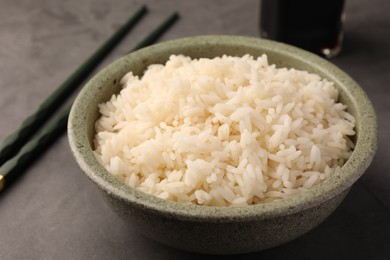 Delicious rice in bowl on grey table, closeup