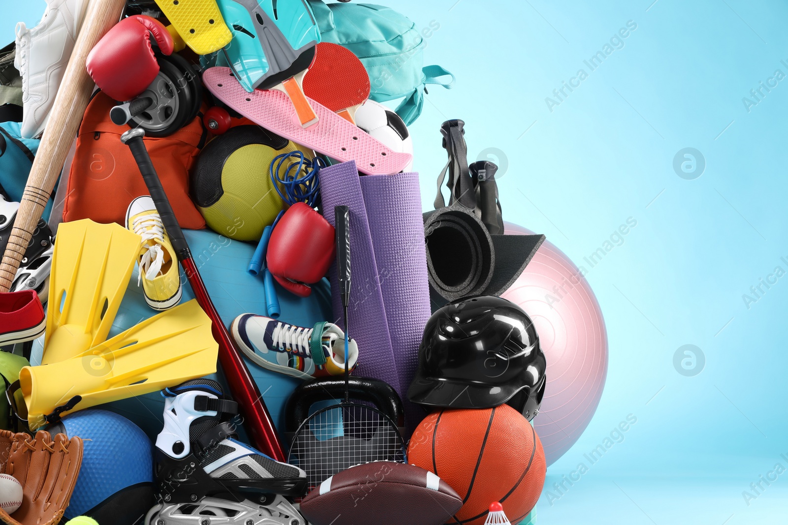 Photo of Many different sports equipment on light blue background