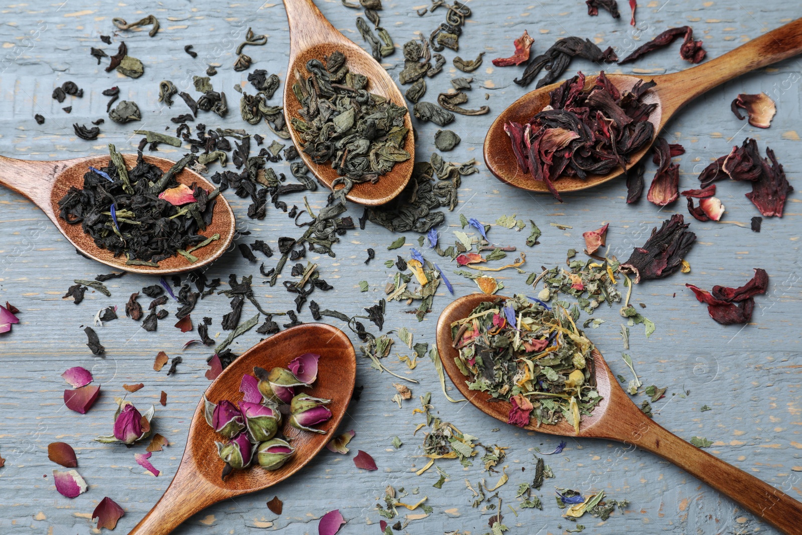 Photo of Flat lay composition with different teas and spoons on grey wooden table