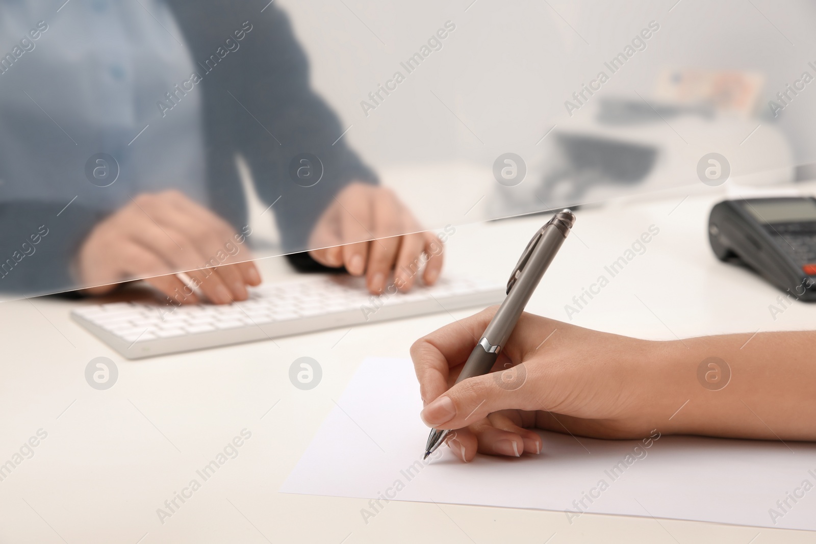 Photo of Woman filling blank at cash department window, closeup