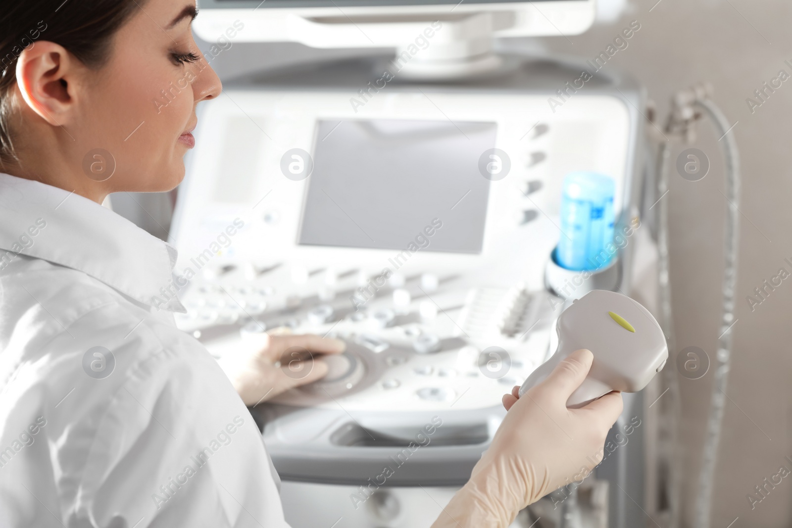 Photo of Sonographer holding ultrasound machine probe in clinic