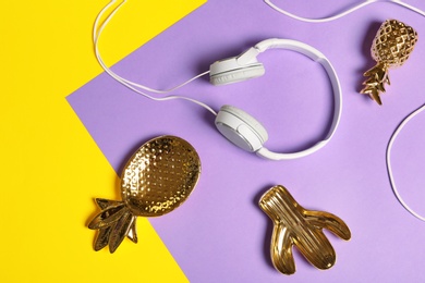 Photo of Flat lay composition with headphones and decorative pineapples on color background