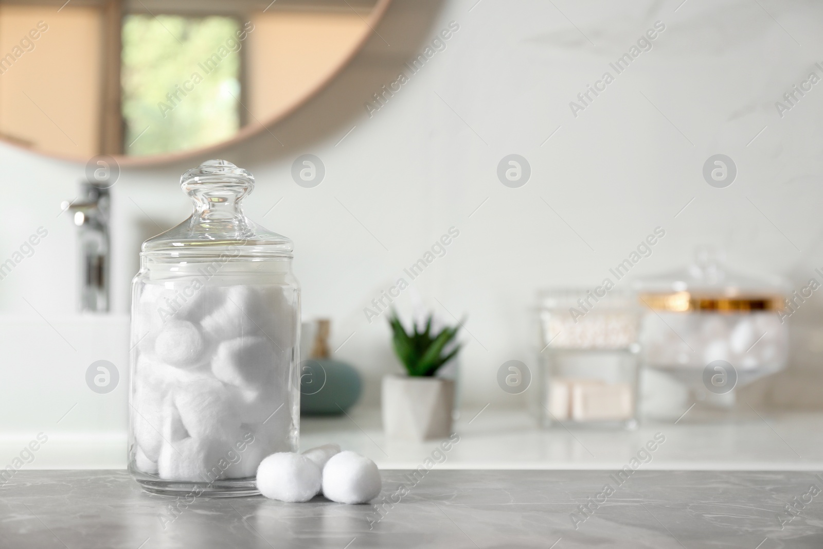 Photo of Cotton balls on light grey marble table in bathroom