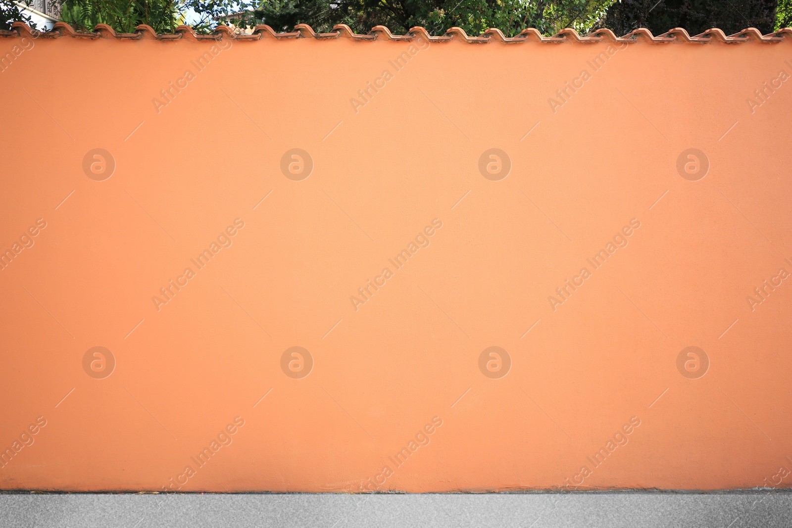 Photo of Beautiful orange wall and concrete sidewalk outdoors