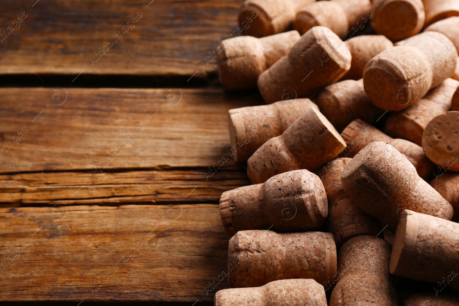 Photo of Sparkling wine bottle corks on wooden table. Space for text