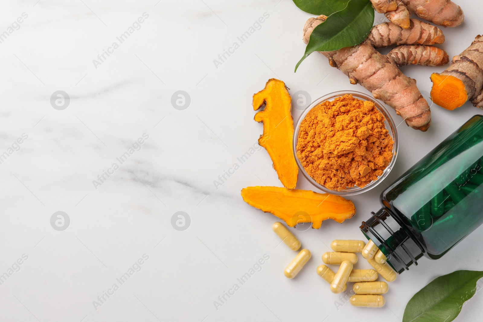 Photo of Aromatic turmeric powder, pills and raw roots on white marble table, flat lay. Space for text