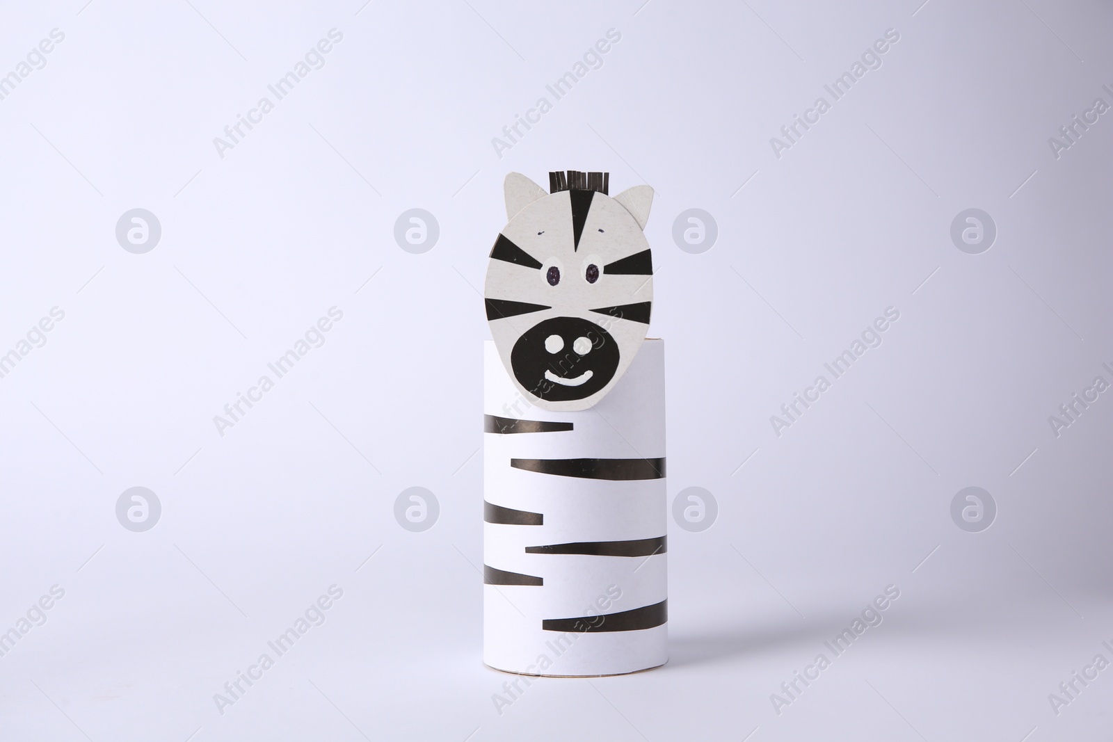 Photo of Toy zebra made from toilet paper hub on white background. Children's handmade ideas