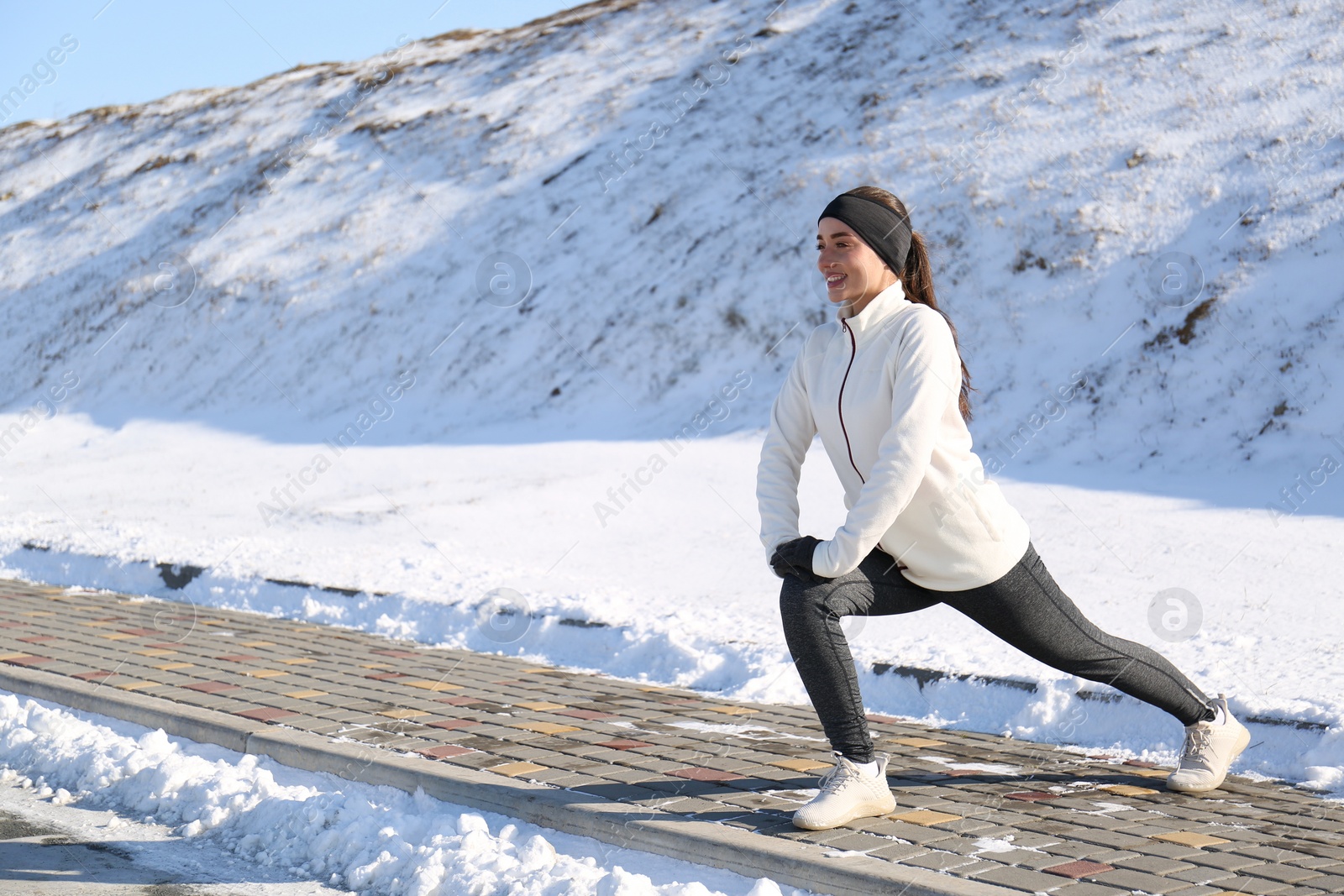 Photo of Woman doing sports exercises outdoors on winter day. Space for text