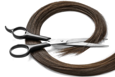 Photo of Brown hair and scissors on white background. Hairdresser service