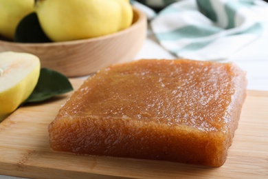 Photo of Delicious quince paste on wooden board, closeup