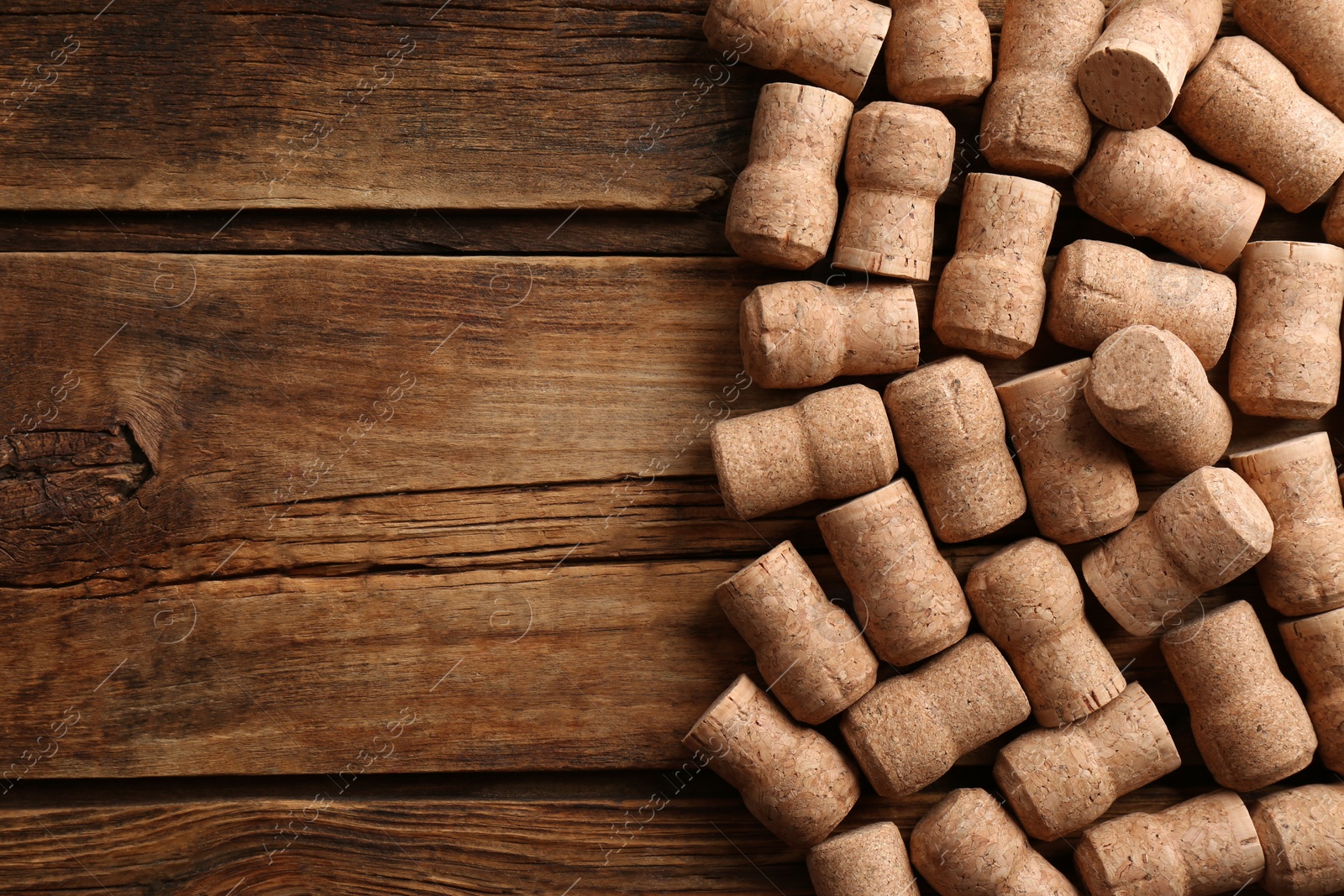 Photo of Sparkling wine bottle corks on wooden table, flat lay. Space for text