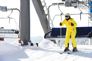 Photo of Woman using chairlift at mountain ski resort. Winter vacation