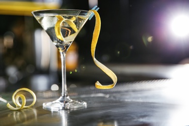 Photo of Glass of lemon drop martini cocktail on bar counter. Space for text