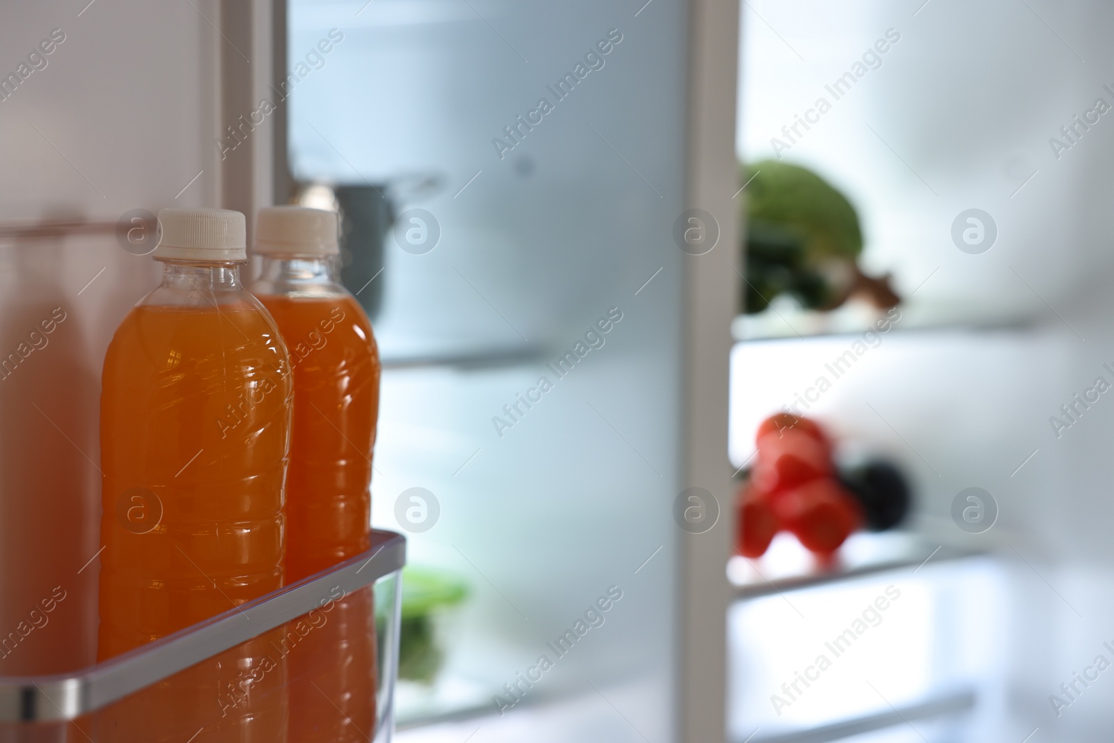 Photo of Open refrigerator with bottles of drink indoors, space for text