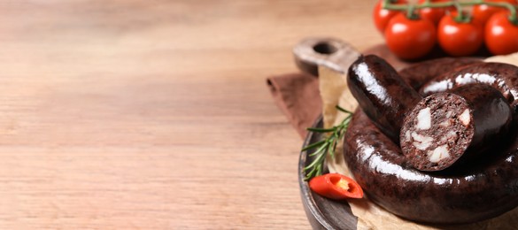 Tasty blood sausages served on wooden table, closeup. Space for text