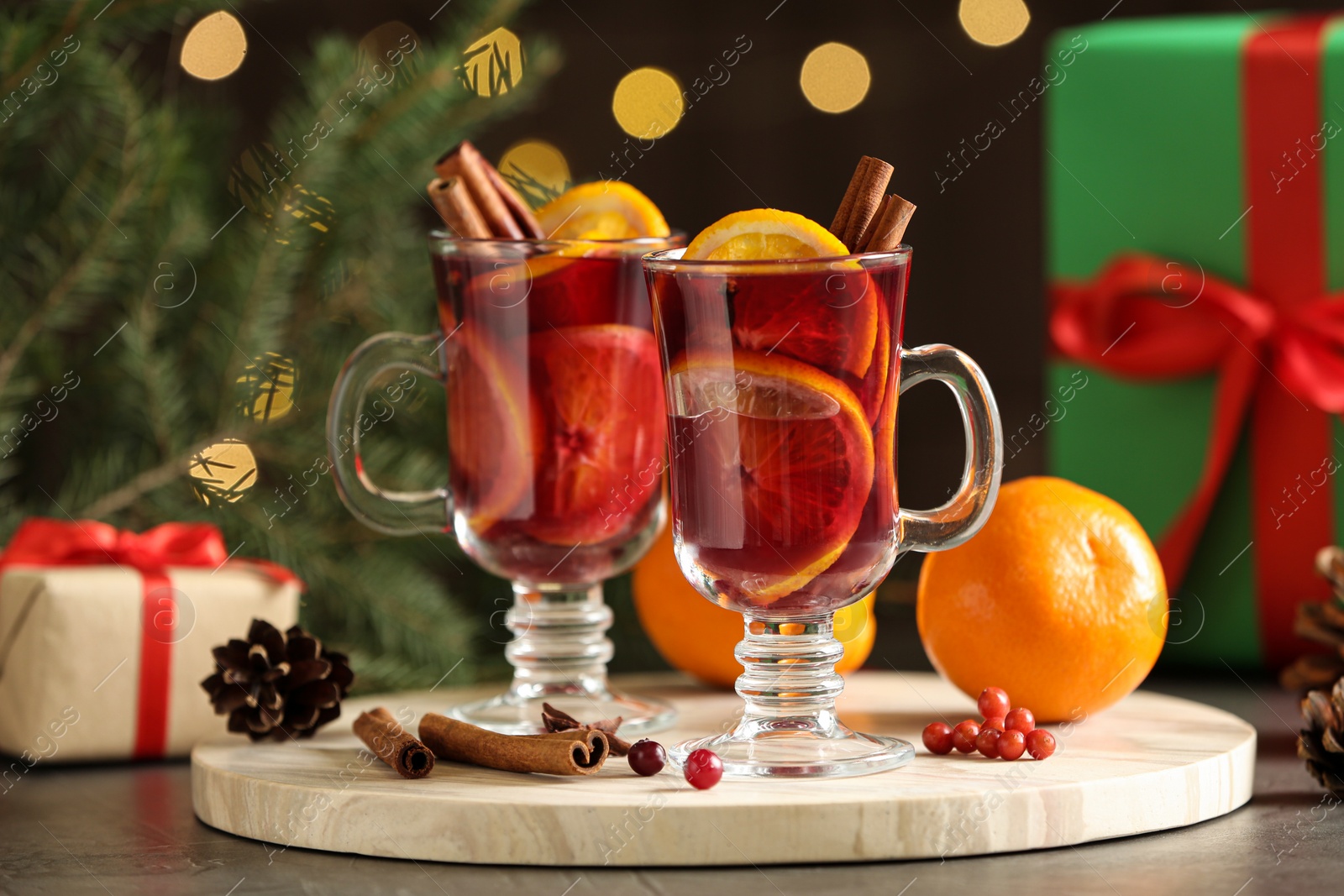 Photo of Marble board with glass cups of mulled wine on table